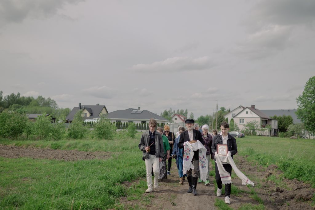 Entouré de ses deux fils, Elias et Maxim, Dorotheus Fionik fête la Saint-Georges dans les champs qui bordent Studziwody. Le quinquagénaire conduit la procession censée assurer de bonnes récoltes à son village. Il est connu pour être l’un des gardiens de la culture de Podlasie. Dorotheus a fondé en 1993 un musée dédié à l’histoire de sa région ; il joue également dans un groupe folklorique et publie le magazine Bielsky Gostinets (« La maison de Bielsk », du nom d’une des principales villes de Podlasie). « Rédigé en polonais, en podlaski et en biélorusse, il rassemble des poèmes, des textes d’artistes locaux, des articles sur l’histoire de la région, des dessins ou des photos d’archives. Dorotheus y mélange les langues pour le rendre plus inclusif », décrit le photographe.