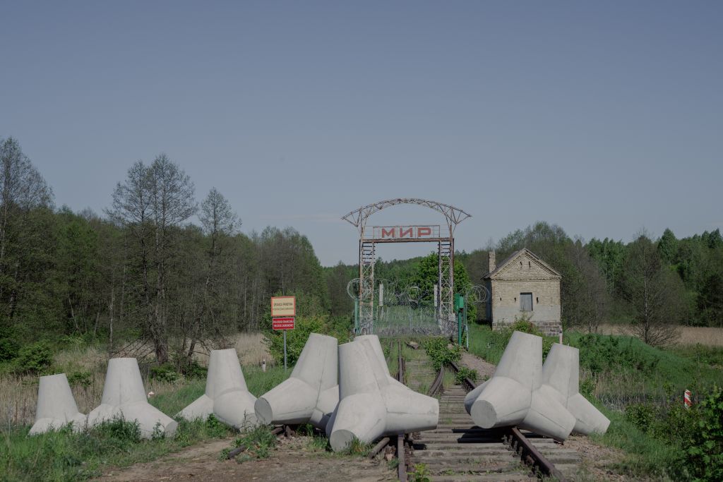 La Podlasie a fait les gros titres de la presse internationale durant l’hiver 2021 quand des milliers de refugiés venus du Moyen-Orient, poussés par le régime de Loukachenko allié à la Russie de Poutine, se sont retrouvés coincés dans le froid des épaisses forêts et des marécages de cette région aux portes de l’Union européenne. Depuis, la Pologne s’est barricadée en fermant ses postes-frontières avec le Bélarus et en érigeant un mur long de 186 kilomètres. « Sur Google Maps, j’ai vu cet ancien poste-frontière de Bobrowniki, situé sur une voie de chemin de fer désaffectée. J’ai voulu voir cet endroit qui évoque visuellement les difficultés de l’exil, un thème qui m’est cher. Il a été clôturé en 2023 par les autorités polonaises pour “raisons de sécurité nationale” maintenant que plane, en outre, la menace d’un conflit direct avec la Russie », rapporte le photographe. L’inscription « МИР », qui signifie paix, se trouve du côté biélorusse.