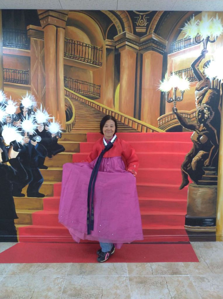 Cette fois-là, en Corée, ils nous ont emmenés dans une salle remplie de différentes robes traditionnelles. Nous pouvions choisir celle qui nous plaisait le plus et prendre une photo avec. J'ai choisi celle-ci parce que j'aimais les couleurs et le long foulard !