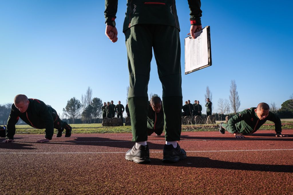 Sous le soleil du petit matin, les recrues enchaînent les tests physiques dans leur jogging aux couleurs de la Légion. Avant leur intégration, ces jeunes militaires ont été interrogés sur leur passé. « La Légion étrangère accepte d’endosser le passé du légionnaire à condition que celui-ci soit intégralement connu », indique son site de recrutement. Pendant des semaines, leurs déclarations sont vérifiées, leur vie passée au crible. « S’ils ont menti, commis des crimes ou consomment des drogues, ils dégagent », résume Fred Marie. Le temps des recherches, les militaires perdent leur identité : leur nom, prénom et date de naissance sont modifiés. Au bout de six mois, ils peuvent récupérer leur identité ou garder la nouvelle. « Cette disposition offre une opportunité à ceux qui veulent tourner une page et qui ont envie de prendre un nouveau départ », explique la Légion. « Cela génère beaucoup de fantasmes, analyse le photographe. Par le passé, la Légion a été peuplée de repris de justice ou d’hommes souhaitant se planquer, notamment à la fin de la Seconde Guerre mondiale. Aujourd’hui, on peut encore trouver des personnes qui veulent faire table rase, mais c’est loin d’être la majorité. »