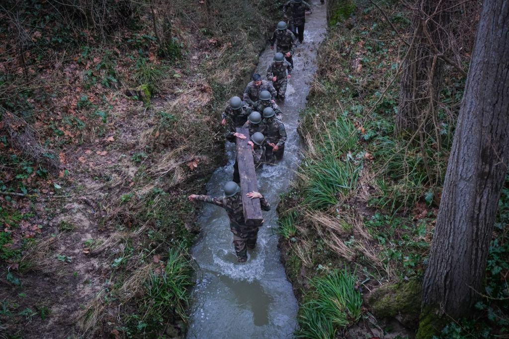 Constitués en équipes, les futurs légionnaires pratiquent ici ce que l’armée appelle « la méthode naturelle », un type d’exercices qui va se répéter à plusieurs reprises au cours de leur formation : au petit matin, après une nuit passée à dormir dehors, ils doivent porter des poutres en bois, ramper dans la boue, sous des barbelés, dans des tuyaux. « Nous sommes en plein hiver et l’eau était glaciale, se souvient le photographe. Le but est de tester leur endurance et leur rusticité, tout autant que leur esprit de groupe. Ils doivent s’entraider, épauler les plus faibles, s’appuyer sur les forces des uns et des autres. Certains vomissent, se blessent, mais je n’ai vu personne craquer. C’est plutôt quelques jours plus tard qu’ont eu lieu les abandons. »