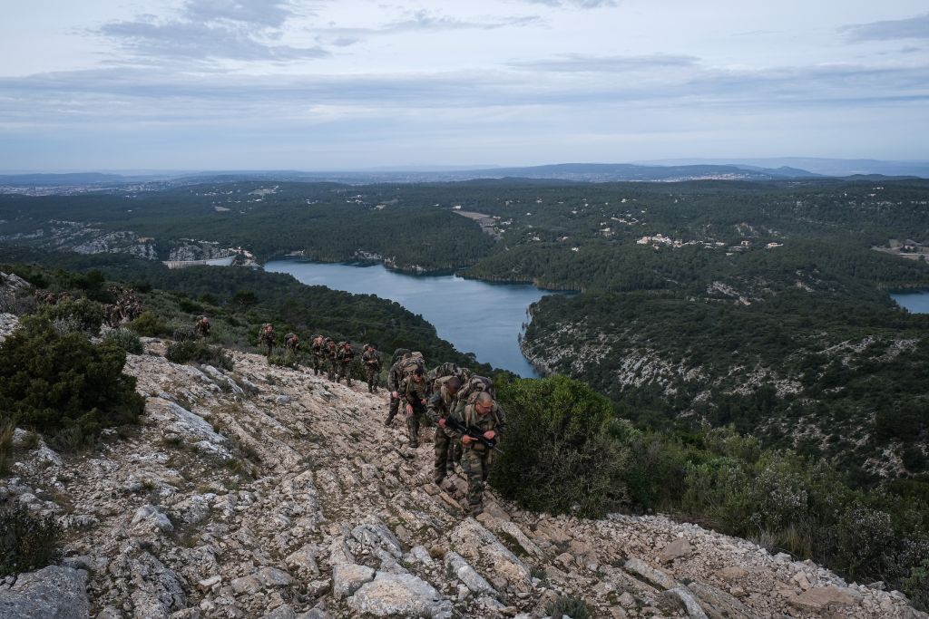 À la fin de leur premier mois de formation, les recrues effectuent la marche dite du « képi blanc » : 70 kilomètres à parcourir en deux jours, chargés d’un paquetage d’une trentaine de kilos, armes comprises. Ceux qui parviennent au bout reçoivent quelques jours plus tard le képi blanc qui fait d’eux des légionnaires. « Le parcours varie selon les années et les sections. Cette fois, les soldats sont partis de l’école militaire d’Aix-en-Provence pour rejoindre le petit village de Puyloubier situé au milieu des vignes. Ils montent ici la montagne Sainte-Victoire qui casse vraiment les jambes. Ce n’est pas de la randonnée, le rythme est soutenu, les pauses rares et courtes », se remémore le photographe.