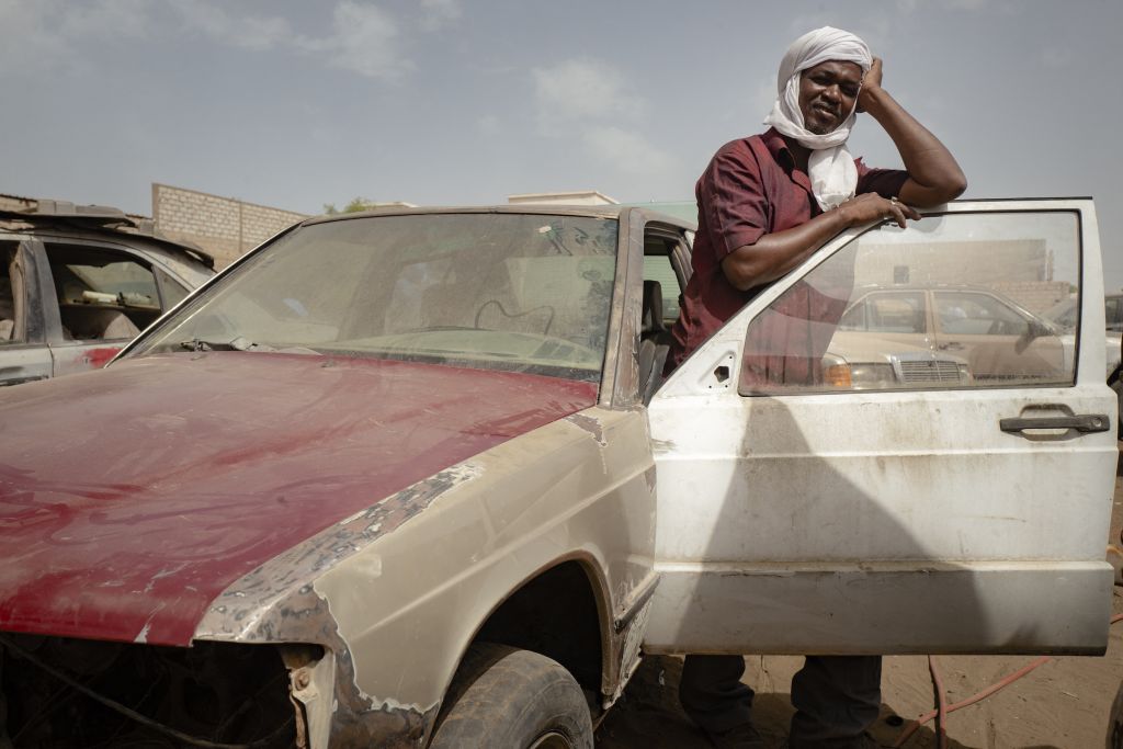 Les Nouakchottois tirent une certaine fierté de leur voiture, comme ce propriétaire qui pose devant un garage de la capitale. « Ce monsieur se souvenait parfaitement de la date d’achat de sa voiture, un 28 janvier… alors que cela remonte aux années 1990 ». À l’usage, la Mercedes 190 est le véhicule idéal pour manœuvrer dans le désert saharien : longue et légère, elle offre selon le photographe une excellente résistance à la chaleur et roule bien sur le sable – à condition de maintenir les pneus presque totalement dégonflés, autour d’un bar de pression, comme le font tous les chauffeurs qu’il a rencontrés. « Au volant de mon Range Rover moderne censé être conçu pour les dunes, témoigne Michele Cattani quand il part en brousse, je me fais constamment dépasser par des vieilles Mercedes déglinguées qui avancent sans effort ».