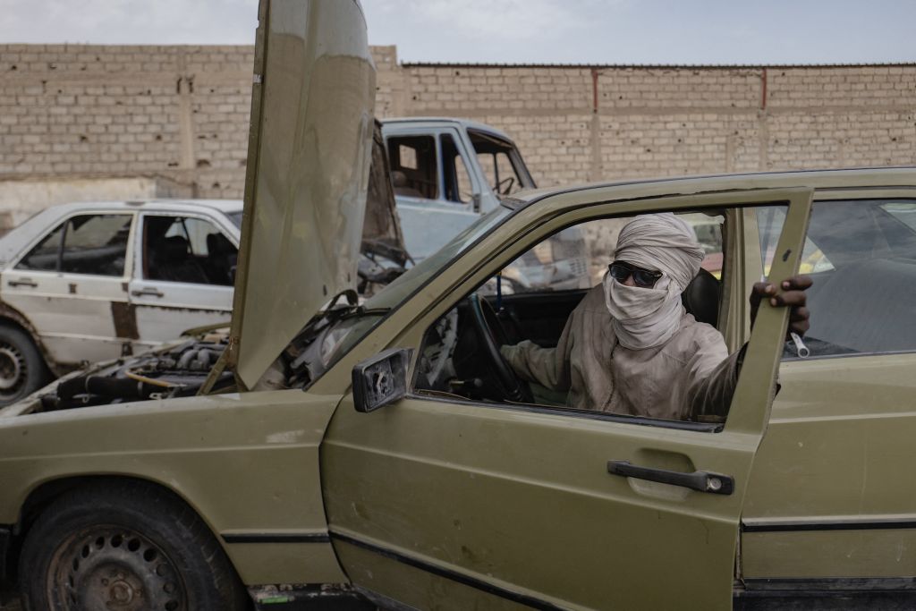 Contrairement à Bamako au Mali ou Dakar au Sénégal, Nouakchott n’est pas une ancienne ville coloniale. Sortie de terre à la fin des années 1950, la capitale s’est étendue à grande vitesse dans un apparent chaos qui désarçonne le citadin occidental. Nouakchott a été qualifiée de l’oxymore « ville nomade », par l’anthropologue Christian Vium en 2016. « Capitale d’un pays de culture nomade, analyse le photographe, elle en a transposé l’esprit » : le tissu urbain y est très étalé, le recours à la voiture systématique, la fin de la ville et le début du désert n’ont pas de limites claires. « Je vois la passion des Mauritaniens pour la voiture comme un symbole de ce passage du nomadisme à la vie sédentaire, ajoute Michele Cattani. Et dans ce transfert, ajoute-t-il à moitié sérieux, « la Mercedes 190D a pris la place du dromadaire ».