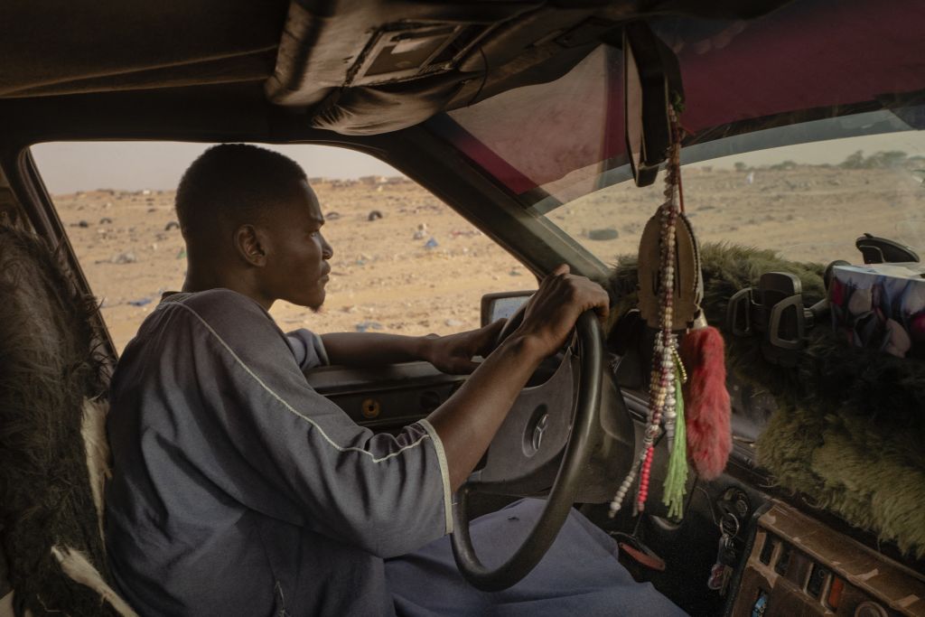 Oussama a la vingtaine et ne possède pas sa propre 190. C’est celle d’un autre qui lui permet d’exercer le métier de taxi en échange d’une rétribution. « Avoir une voiture, c’est plus qu’un moyen de transport à Nouakchott : c’est la garantie de pouvoir gagner de l’argent, en faisant le taxi ou en transportant des marchandises d’une ville à l’autre », explique le photographe. À l’avant, la moquette verte est une fausse fourrure synthétique que les conducteurs mauritaniens placent devant le pare-brise pour éviter que le soleil ne fasse exploser le plastique. Cela sert aussi à fixer des objets. « Ici, les gens aiment leur voiture au point de la customiser à fond. Ils veulent leur donner une personnalité. »