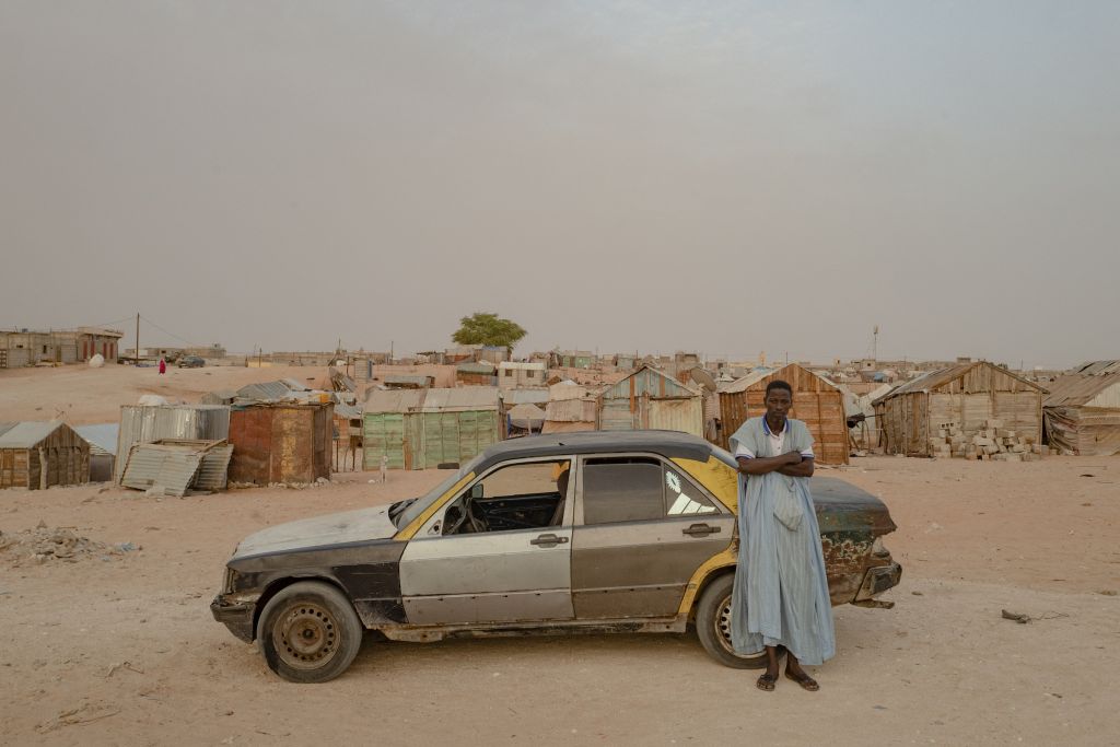 Le quartier de Tarhil se trouve aux confins de Nouakchott, à la périphérie sud-est de la capitale. Créé à l’origine pour accueillir des réfugiés liés à la sécheresse, les logements y sont rudimentaires, l’accès à l’eau dépend du passage d’un camion-citerne qu’attendent les habitants tous les soirs. Michele Cattani marchait seul dans ce bidonville quand il a vu cette 190. Il s’est mis à la photographier jusqu’à ce que son propriétaire s’avance vers lui, l’œil interrogateur.