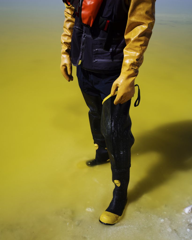 mineur en bottes dans une boue jaune