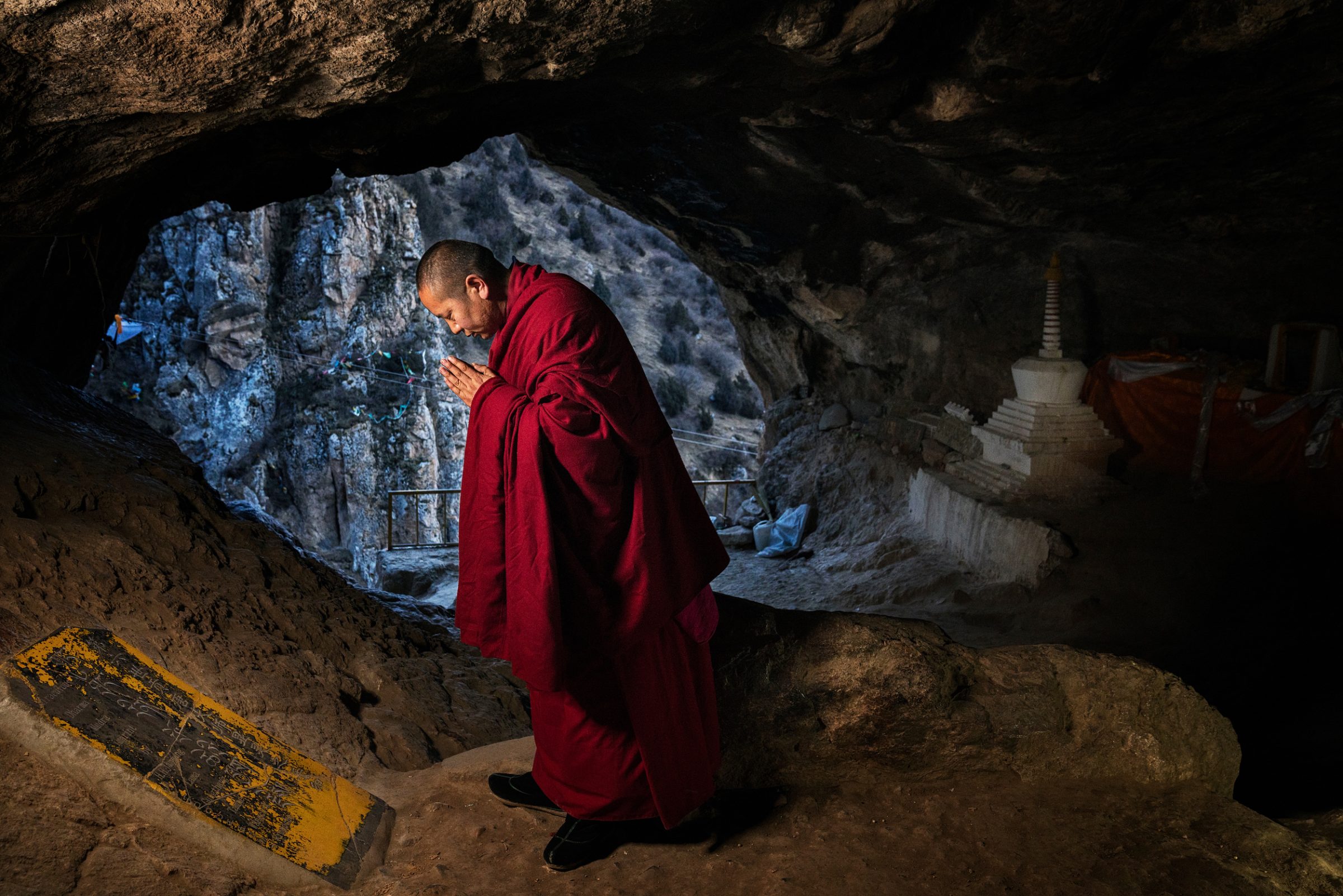 moine bouddhiste priant dans une grotte