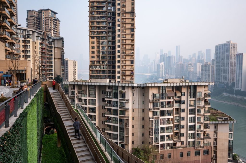 homme montant des escaliers au milieu de grands immeubles