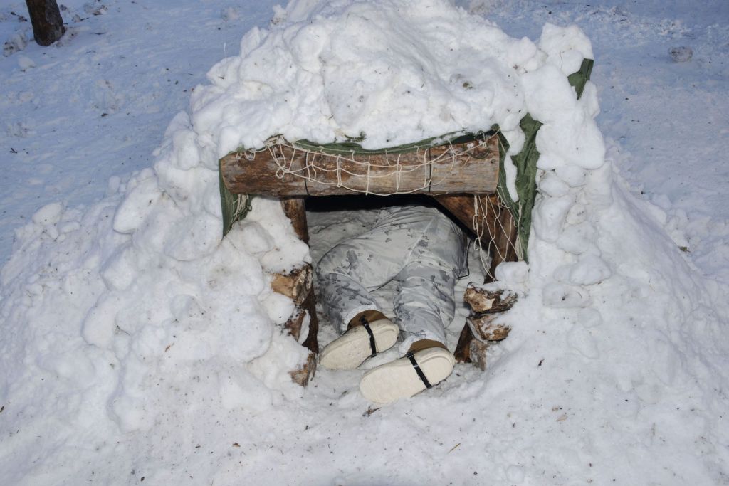 militaire construisant un abri dans la neige