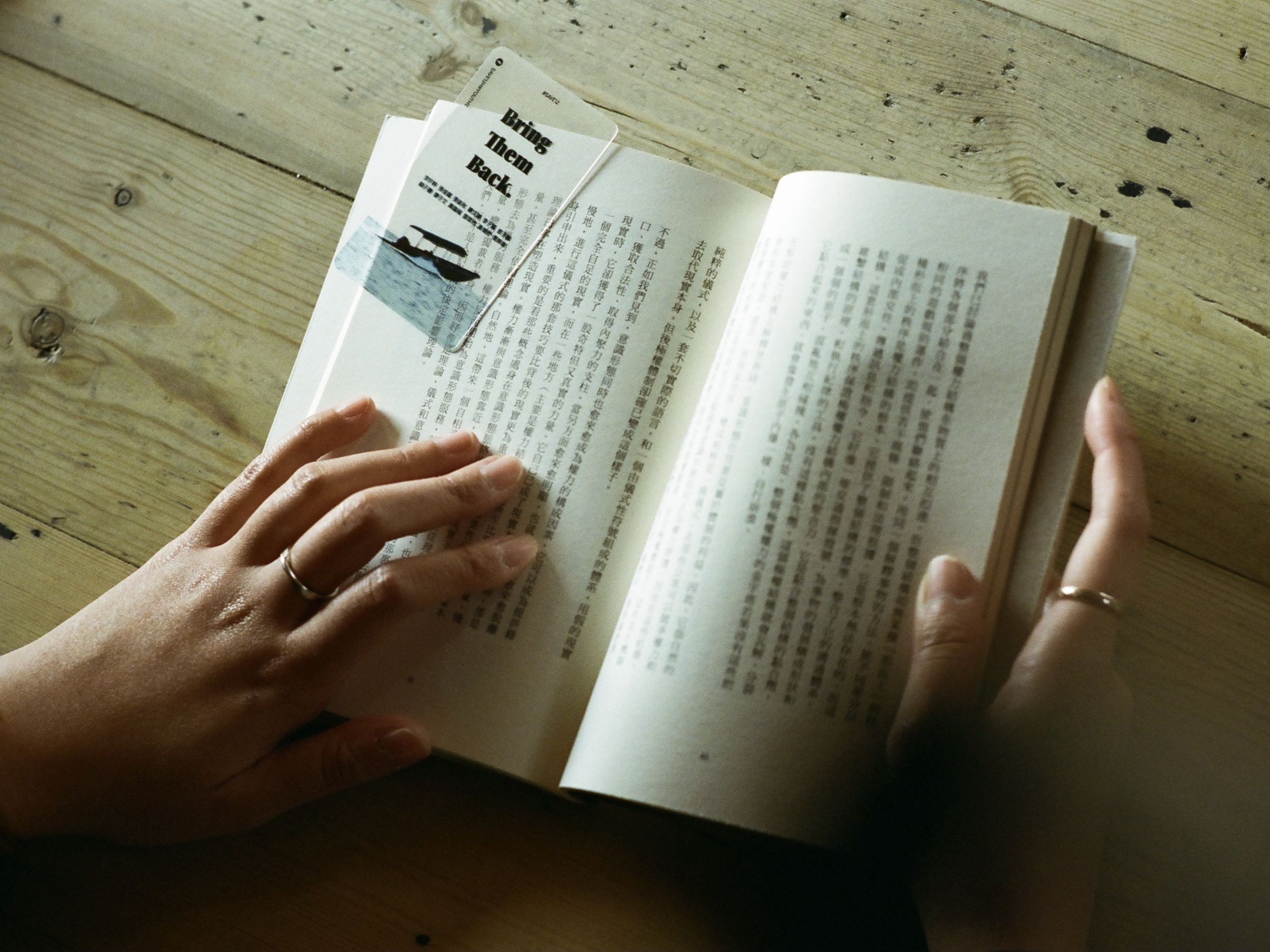 Un livre en caractères chinois, tenu en main