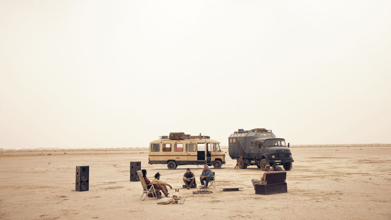 personnages assis sur des canapés dans le désert