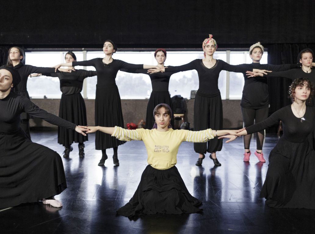 Des danseuses se tenant par la main sur deux rangs