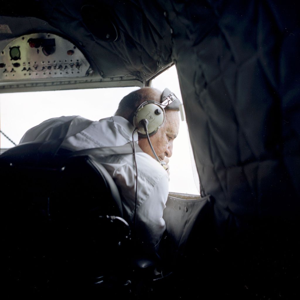 Le pilote dans sa cabine regarde par le hublot.