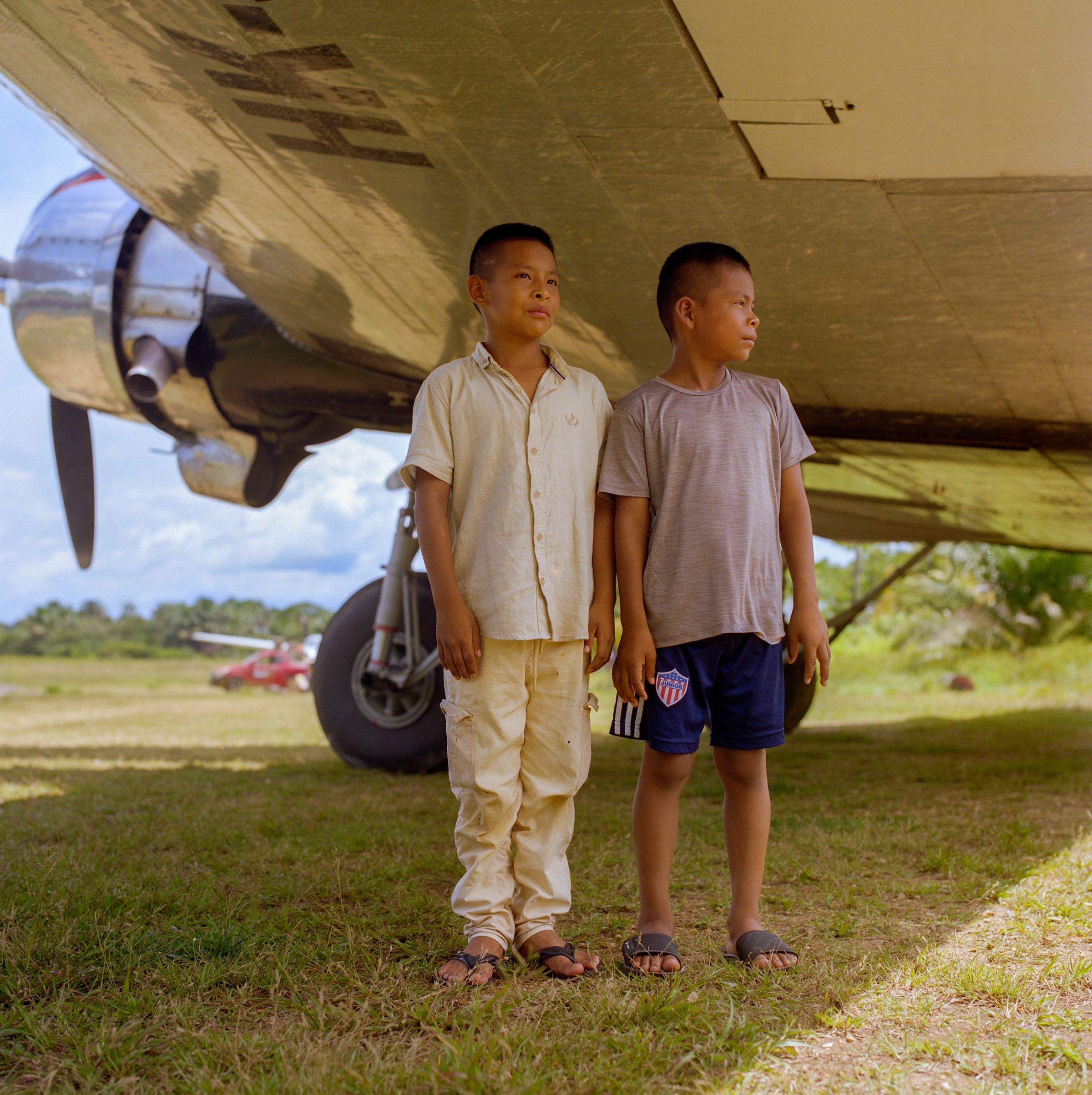 Deux enfants sous l'aile d'une avion.