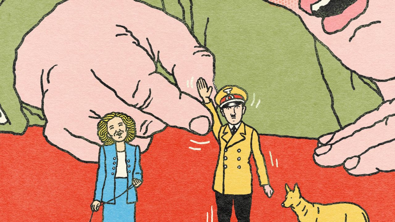 Un homme joue avec une figurine d'Hitler et d’Eva Braun