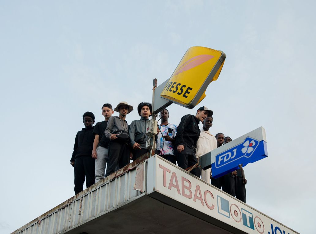 Des jeunes sur le toit d’un bureau de tabac