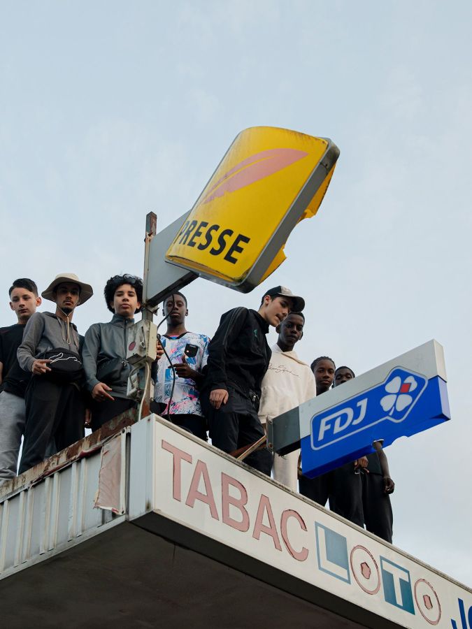 Des jeunes sur le toit d’un bureau de tabac