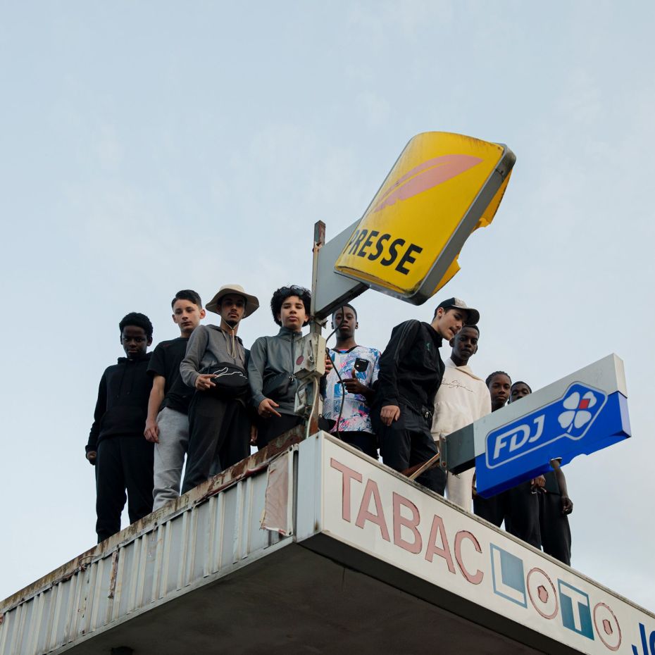 Des jeunes sur le toit d’un bureau de tabac
