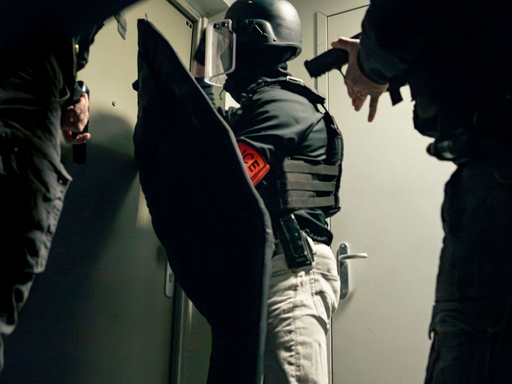 Des policiers devant une porte avant une intervention