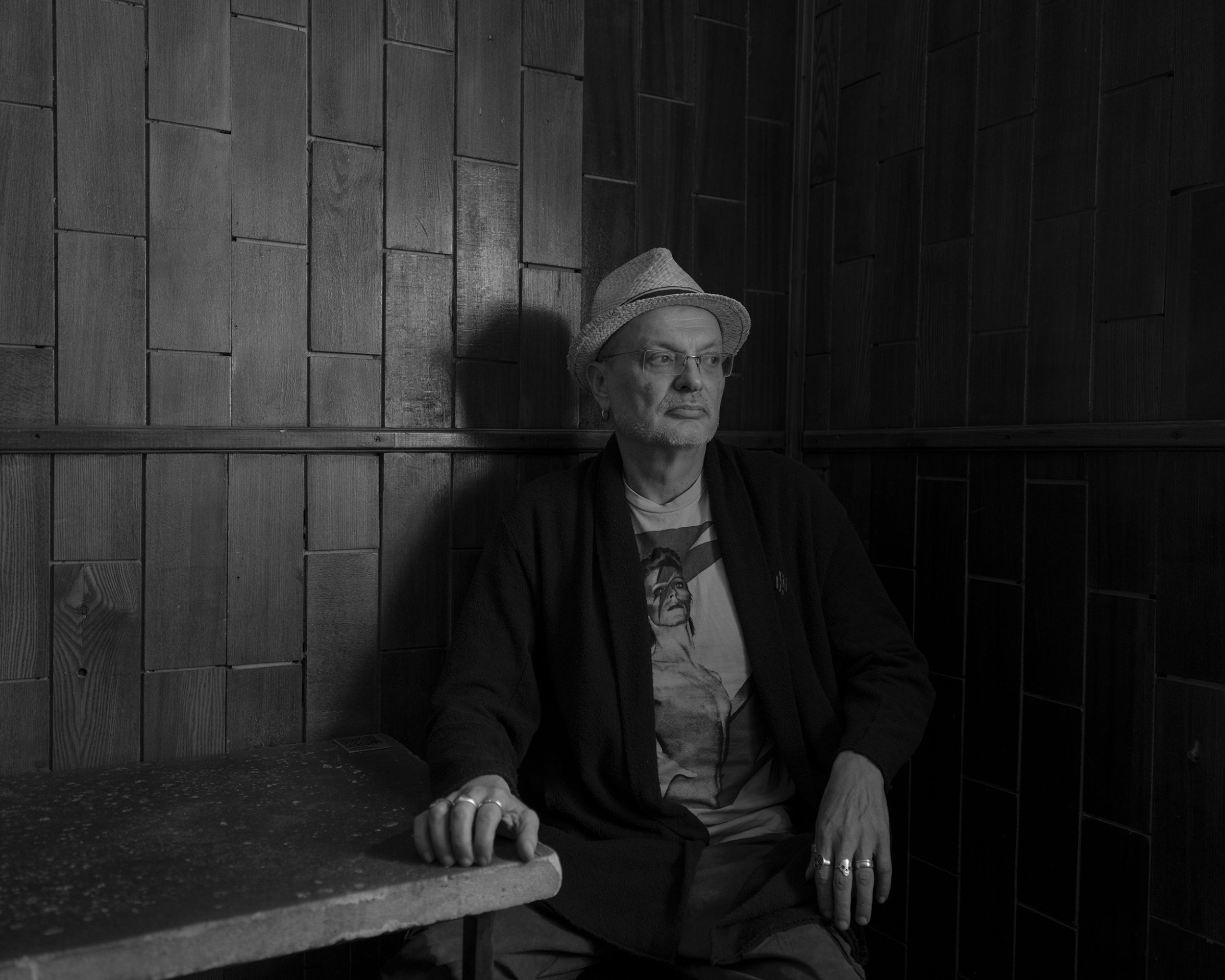 un homme assis avec un chapeau