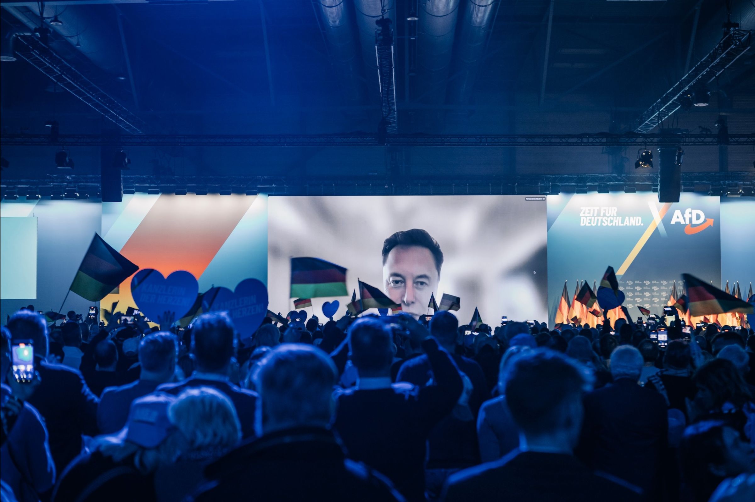Elon Musk sur un écran dans un meeting de l'AfD