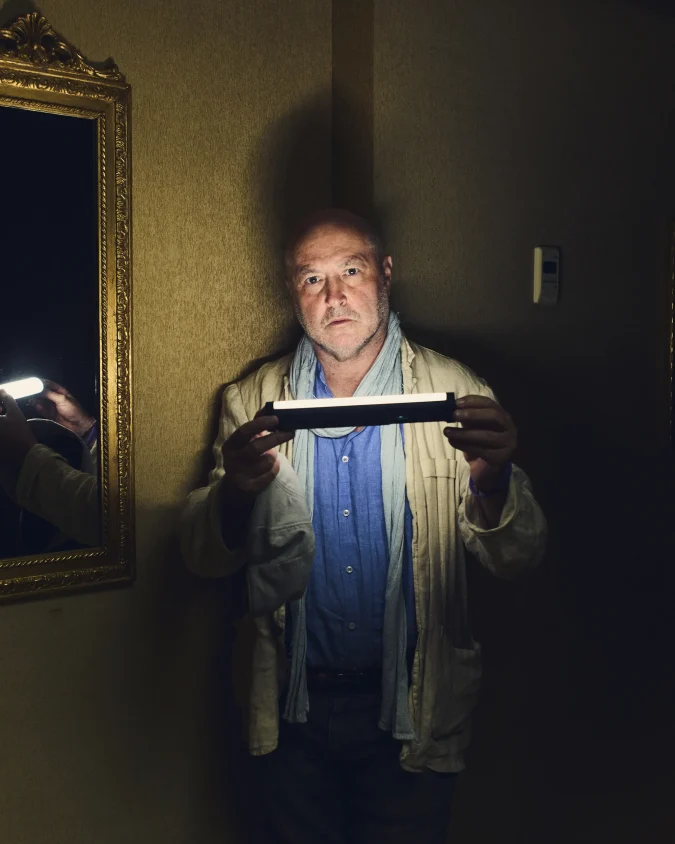 Colum McCann tenant une lampe